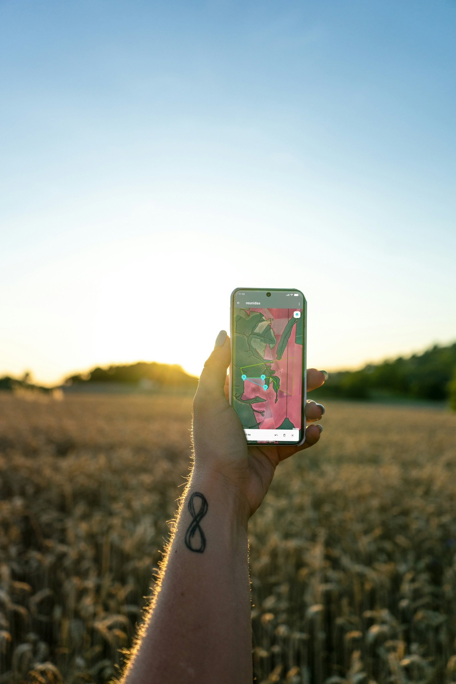 Produtor rural com o app da Agrotecia aberto no celular, em meio à lavoura